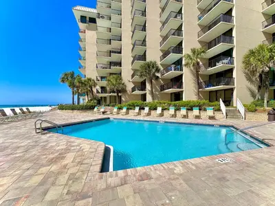 a swimming pool in front of a large apartment building at Pelican Walk 504 in Panama City Beach