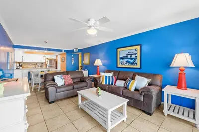 a living room with two couches and a table at Pelican Walk 210 in Panama City Beach
