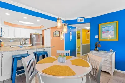 a kitchen and dining room with a table and chairs at Pelican Walk 210 in Panama City Beach