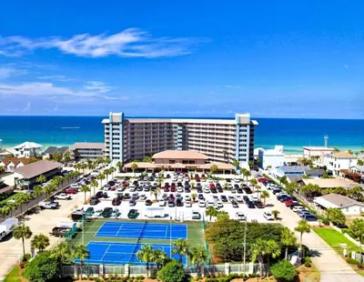 a hotel with a parking lot and a tennis court at Pelican Walk 210 in Panama City Beach