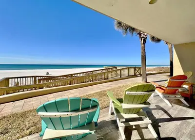 a group of chairs sitting on a patio near the beach at Pelican Walk 106 in Panama City Beach