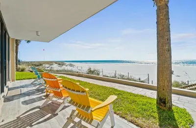 a row of chairs sitting on a porch overlooking the water at Pelican Walk 106 in Panama City Beach