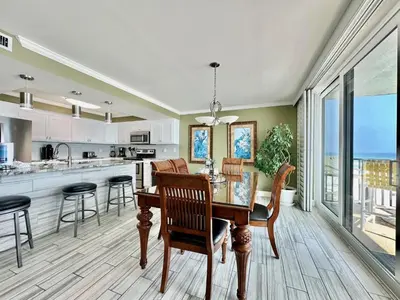 a kitchen and dining room with a table and chairs at Pelican Walk 506 in Panama City Beach