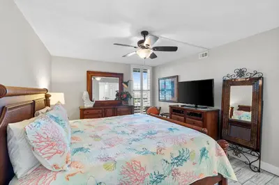 a bedroom with a bed and a flat screen tv at Pelican Walk 506 in Panama City Beach