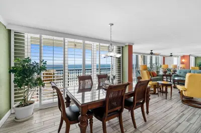a dining room and living room with a table and chairs at Pelican Walk 506 in Panama City Beach