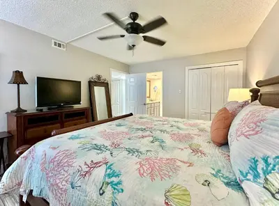 a bedroom with a bed and a flat screen tv at Pelican Walk 506 in Panama City Beach