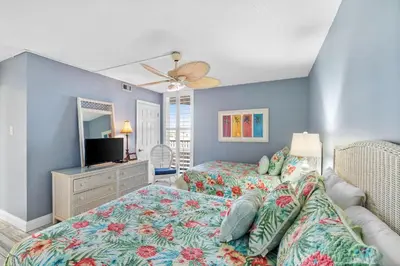 a bedroom with a bed and a flat screen tv at Pelican Walk 506 in Panama City Beach