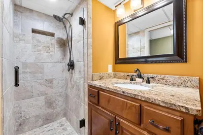 a bathroom with a shower and a sink and a mirror at Pelican Walk 211 in Panama City Beach