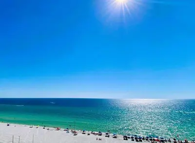 a beach with a group of people and the ocean at Pelican Walk 601 in Panama City Beach