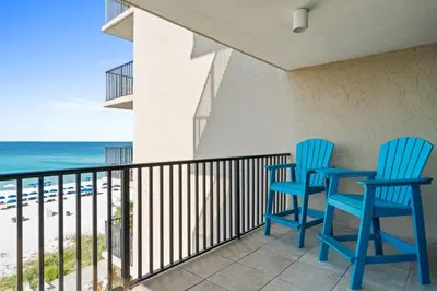 two blue chairs sitting on a balcony overlooking the beach at Pelican Walk 601 in Panama City Beach