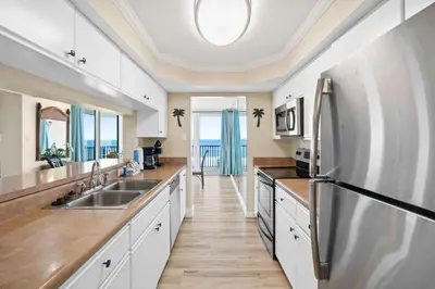 a kitchen with a sink and a refrigerator at Pelican Walk 601 in Panama City Beach