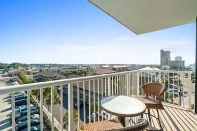 a balcony with a table and chairs and a view of the city at Pelican Walk 601 in Panama City Beach