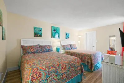 a hotel room with two beds and a television at Pelican Walk 601 in Panama City Beach