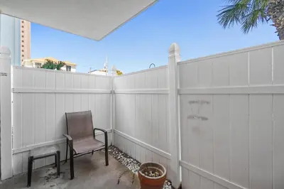 a chair sitting on the side of a fence at Pelican Walk 112 in Panama City Beach