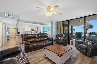 a living room with leather furniture and a ceiling fan at Pelican Walk 112 in Panama City Beach
