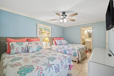 a bedroom with two beds and a ceiling fan at Pelican Walk 112 in Panama City Beach