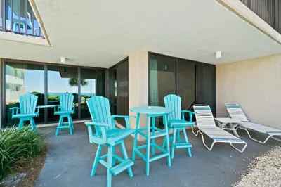 a patio with blue chairs and a table at Pelican Walk 112 in Panama City Beach