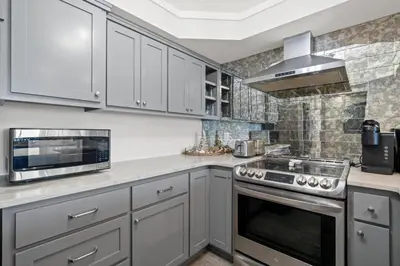 a kitchen with white cabinets and a stove top oven at Pelican Walk 604 in Panama City Beach