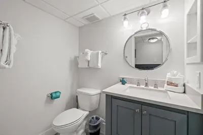 a bathroom with a toilet and a sink and a mirror at Pelican Walk 604 in Panama City Beach