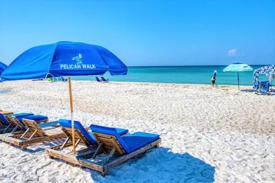 a group of chairs and an umbrella on a beach at Pelican Walk 604 in Panama City Beach