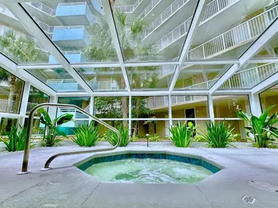 a large building with a hot tub in a courtyard at Pelican Walk 604 in Panama City Beach