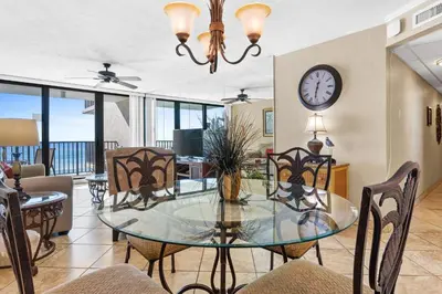 a dining room with a glass table and chairs at Pelican Walk 402 in Panama City Beach
