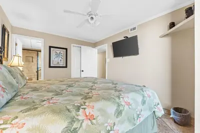 a bedroom with a bed and a flat screen tv at Pelican Walk 402 in Panama City Beach