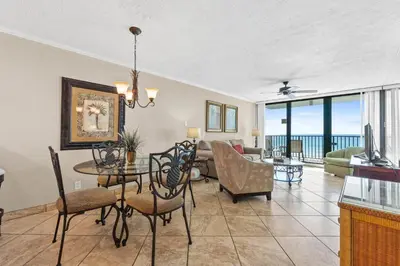 a living room with a table and chairs and a couch at Pelican Walk 402 in Panama City Beach