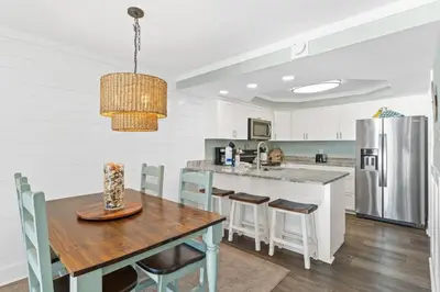 a kitchen with a wooden table and a refrigerator at Pelican Walk 611 in Panama City Beach