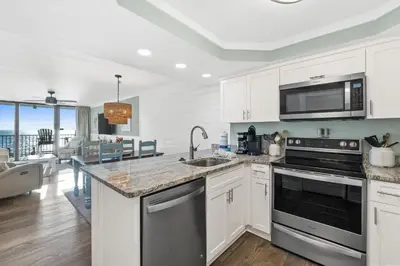 a kitchen with white cabinets and stainless steel appliances at Pelican Walk 611 in Panama City Beach