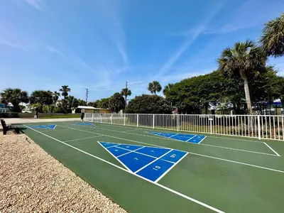 a tennis court with palm trees in the background at Pelican Walk 611 in Panama City Beach