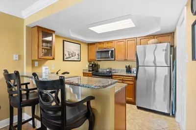 a kitchen with a stainless steel refrigerator and cabinets at Pelican Walk 609 in Panama City Beach