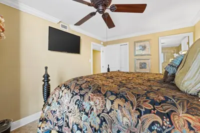 a bedroom with a bed with a ceiling fan at Pelican Walk 609 in Panama City Beach