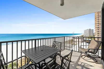 a table and chairs on a balcony with the ocean at Pelican Walk 609 in Panama City Beach