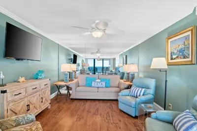 a living room with a couch and a tv at Pelican Walk 408 in Panama City Beach