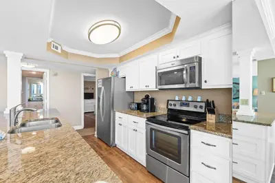 a kitchen with white cabinets and stainless steel appliances at Pelican Walk 408 in Panama City Beach