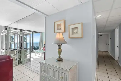 a lamp on a table in a living room with a view of the ocean at Pelican Walk 902 in Panama City Beach