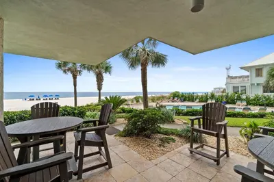 a patio with tables and chairs and a view of the beach at Pelican Walk 108 in Panama City Beach