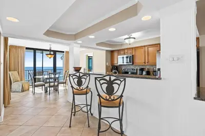 a kitchen and dining room with a view of the ocean at Pelican Walk 1005 in Panama City Beach