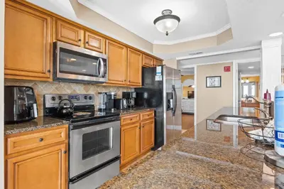 a kitchen with wooden cabinets and stainless steel appliances at Pelican Walk 1005 in Panama City Beach