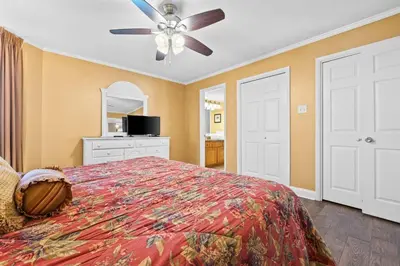 a bedroom with a bed and a ceiling fan at Pelican Walk 1005 in Panama City Beach