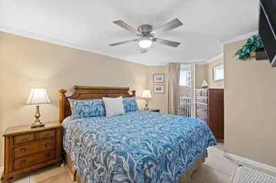 a bedroom with a bed and a ceiling fan at Pelican Walk 410 in Panama City Beach