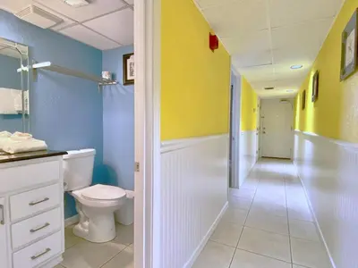 a bathroom with a toilet and yellow and blue walls at Pelican Walk 410 in Panama City Beach
