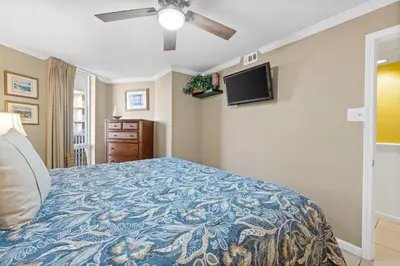 a bedroom with a bed and a flat screen tv at Pelican Walk 410 in Panama City Beach