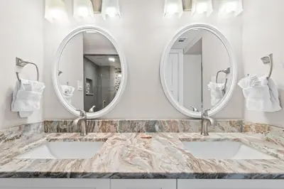 a bathroom with two sinks and two mirrors at Pelican Walk 501 in Panama City Beach