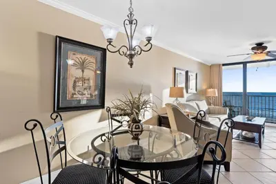 a dining room and living room with a table and chairs at Pelican Walk 502 in Panama City Beach