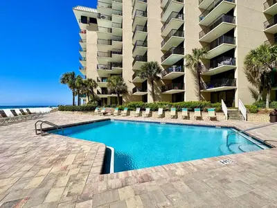 a swimming pool in front of a large apartment building at Pelican Walk 502 in Panama City Beach