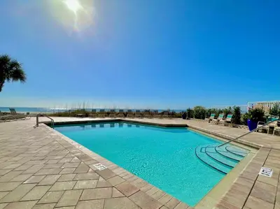 a swimming pool with blue water in a resort at Pelican Walk 502 in Panama City Beach