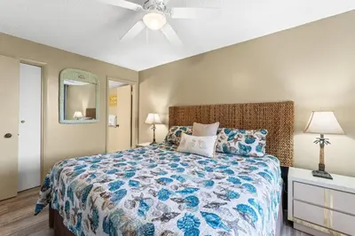 a bedroom with a bed and a ceiling fan at Pelican Walk 1009 in Panama City Beach