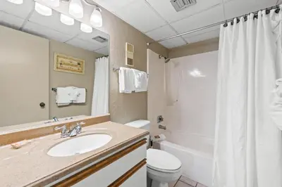 a bathroom with a sink and a toilet and a shower at Pelican Walk 1009 in Panama City Beach